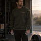 The Glory Be Crew in Olive worn in a garage gym