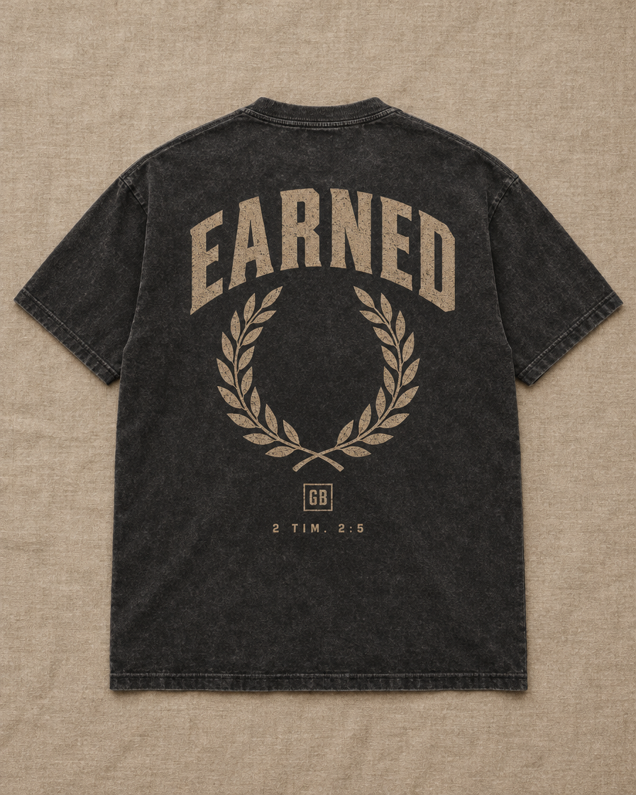 The Earned Tee in Washed Black, back: EARNED, laurel wreath, GB, 2 Tim. 2:5